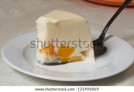 This is a wedge of jelly cake. The cake contains cream and peaches.