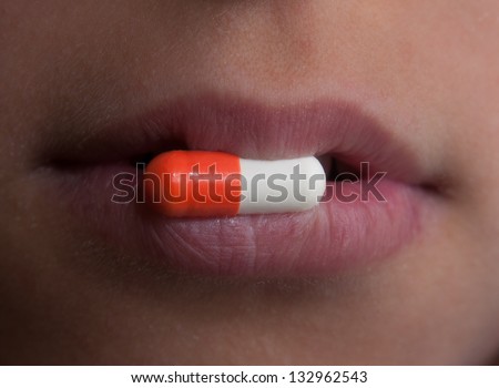 This is a close-up of  pill. Somebody keeps a pill in the lips.