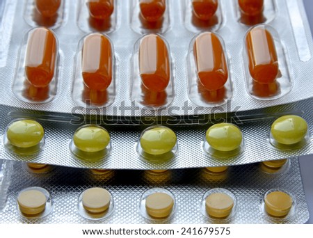This is a close-up of pills in its package. Medicaments are multicolored.