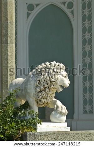 The marble lion sculpture is situated on the Southern veranda of Vorontsov palace (Alupka, Crimea). The animal sculpture is sunlit.