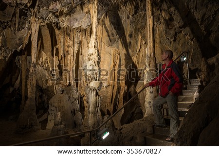The man look for illuminated dropstones, stalactites in the Szent Istvan cave (Hungary, Miskolc,  Lillafured).