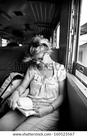 Woman reading book on a train
