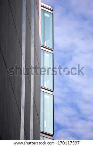 Three office block windows against a blue sky