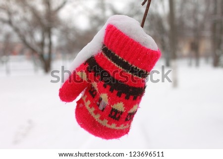Red mitten in the snow in winter
