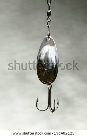 Wet steel fishing lure close-up, fishing background