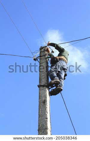 Electrician working on electric power pole