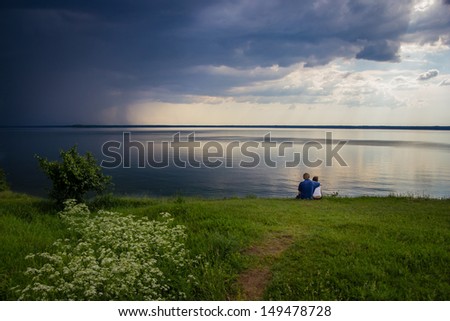 Young couple at the lake when the bad weather is coming