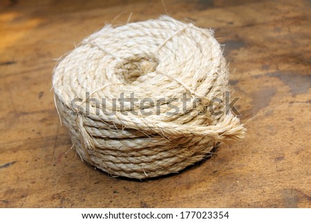 Coiled small amount of rope over wood background