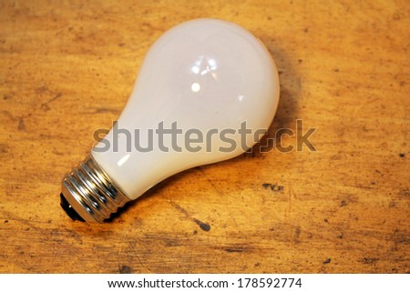 Incandescent light bulb isolated over wood background