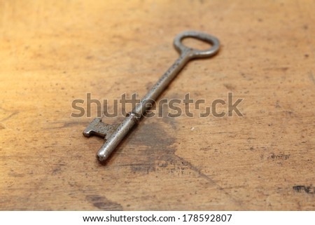 Single antique key on old wood table