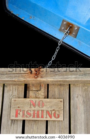 No fishing sign with boat chained to dock