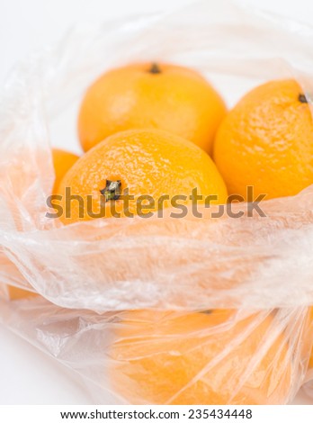 Mandarins in the opened polyethylene bag closeup isolated