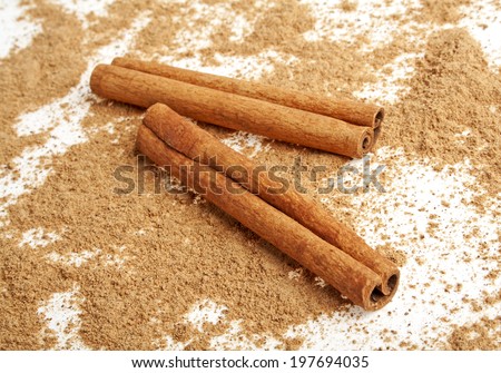 Cinnamon sticks with its dust around it over a white background