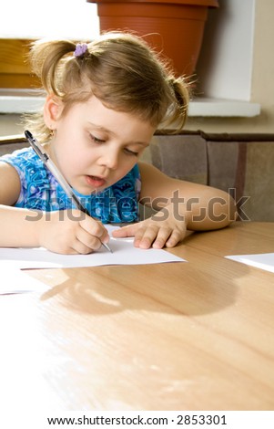 small girl learns to write, seat at a table