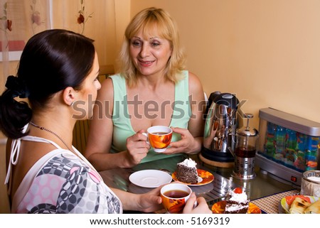 Mother and daughter drinking tea. Focus point on a adult women.