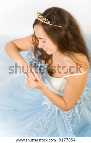 Beauty bride with crown looking ring on a finger