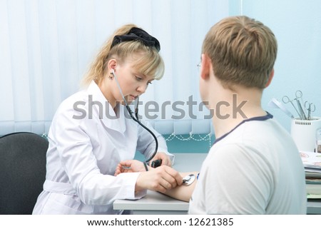 Doctor checking blood pressure of man