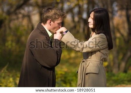 Young caucasian romantic man kissing girls hand