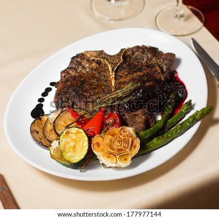 Image of tasty t-bone steak with vegetables in restaurant
