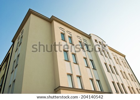 Photo of a clean block of flats from the bottom. Classical architecture business building.