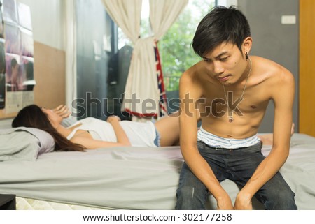 sexual problems, man upset sitting on the bed with women on the back