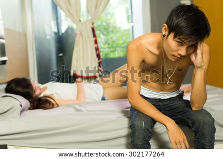 sexual problems, man upset sitting on the bed with women on the back