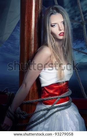 The beautiful girl, in the white dress, adhered to a ship mast