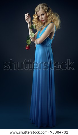 Beautiful girl in dark blue dress with rose