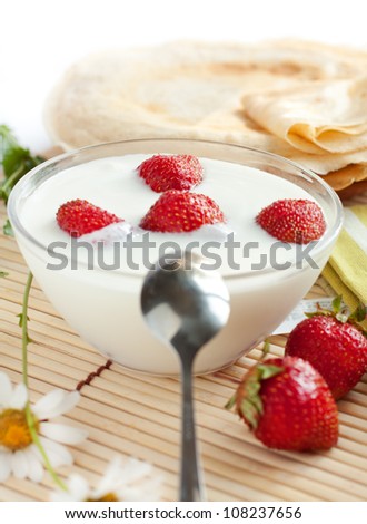Yogurt with strawberries and flavored pancakes, closeup