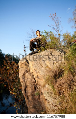 Person resting on the nature. Man sitting on the rock