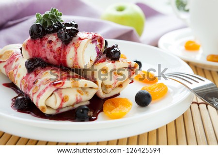 pancakes with cottage cheese in the middle and berry sauce, closeup