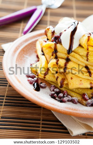golden thin pancakes with sweet sauce, closeup