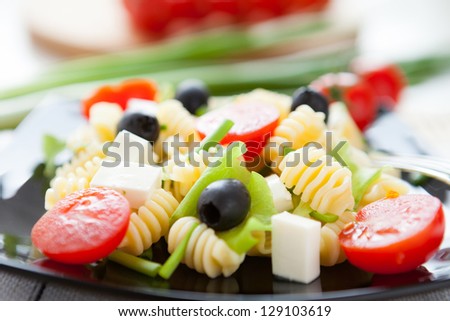 cooked macaroni with vegetables and feta, closeup