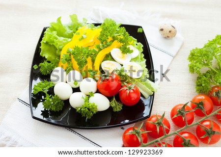 vegetable salad with boiled quail eggs, closeup