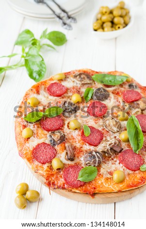 round pizza with slices of salami on white boards, food