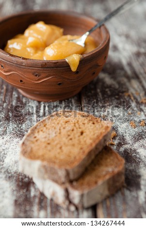 Buckwheat honey in a ceramic bowl and brown bread, food