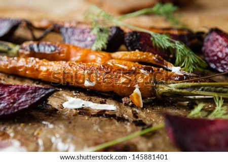 roasted baby carrots and beets with sour cream, close up