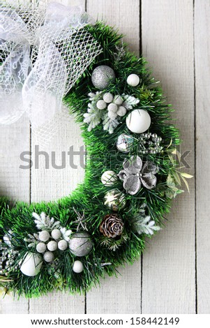 Christmas wreath in silver on white door, food close up