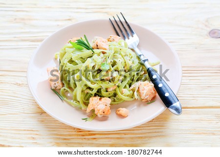 pasta with spinach juice and slices of salmon, food closeup