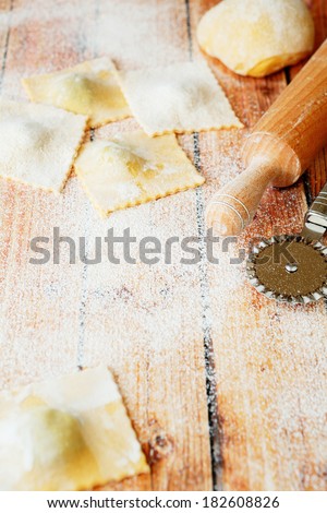 ravioli stuffed with cheese and rolling pin on the table, food closeup