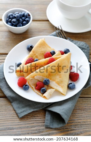 delicious pancakes, crepes with raspberries and blueberries, food closeup