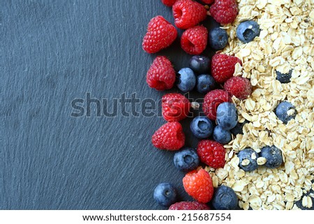 Healthy breakfast and berries on slate background, close-up