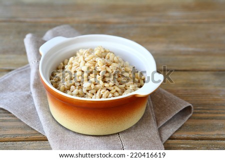 Pearl barley in a ceramic pot, healthy food