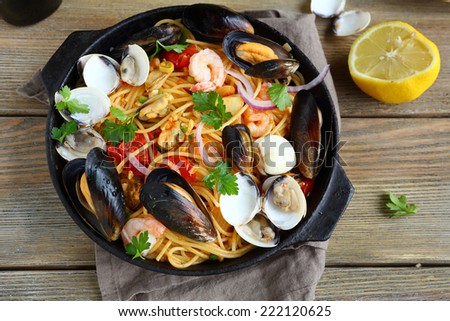 Tasty pasta with mussels, squid, parsley and lemon, top view