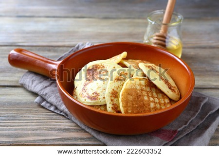 nutritious pancakes with honey on a ceramic pan, delicious food