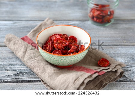 Sun dried cherry tomatoes in a bowl, wooden background