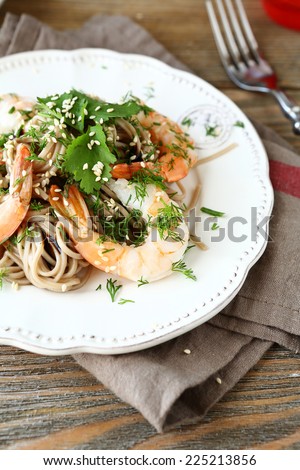Soba with shrimp and greens on white plate, nutritious food