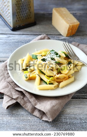 Tasty Penne with cheese and onions on a plate, tasty italian food