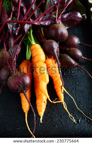 Fresh carrots with beets on a black background, food