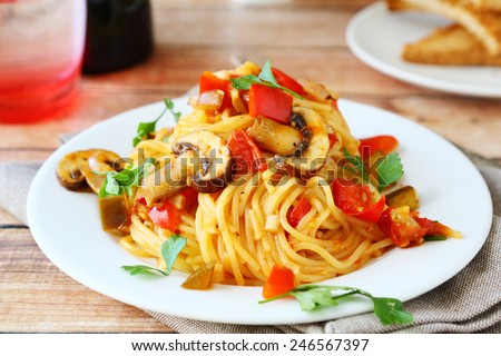 Spaghetti with mushrooms and peppers on a white plate, food